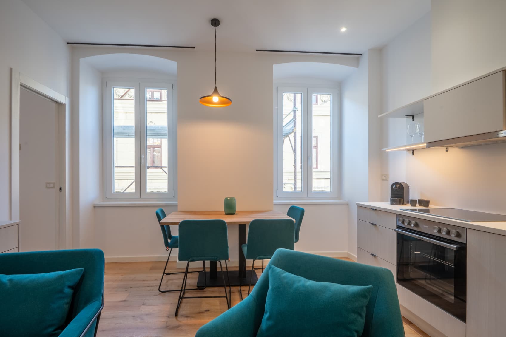 View into the living room, which shows the fully equipped kitchen and open plan eating space for 4 people.