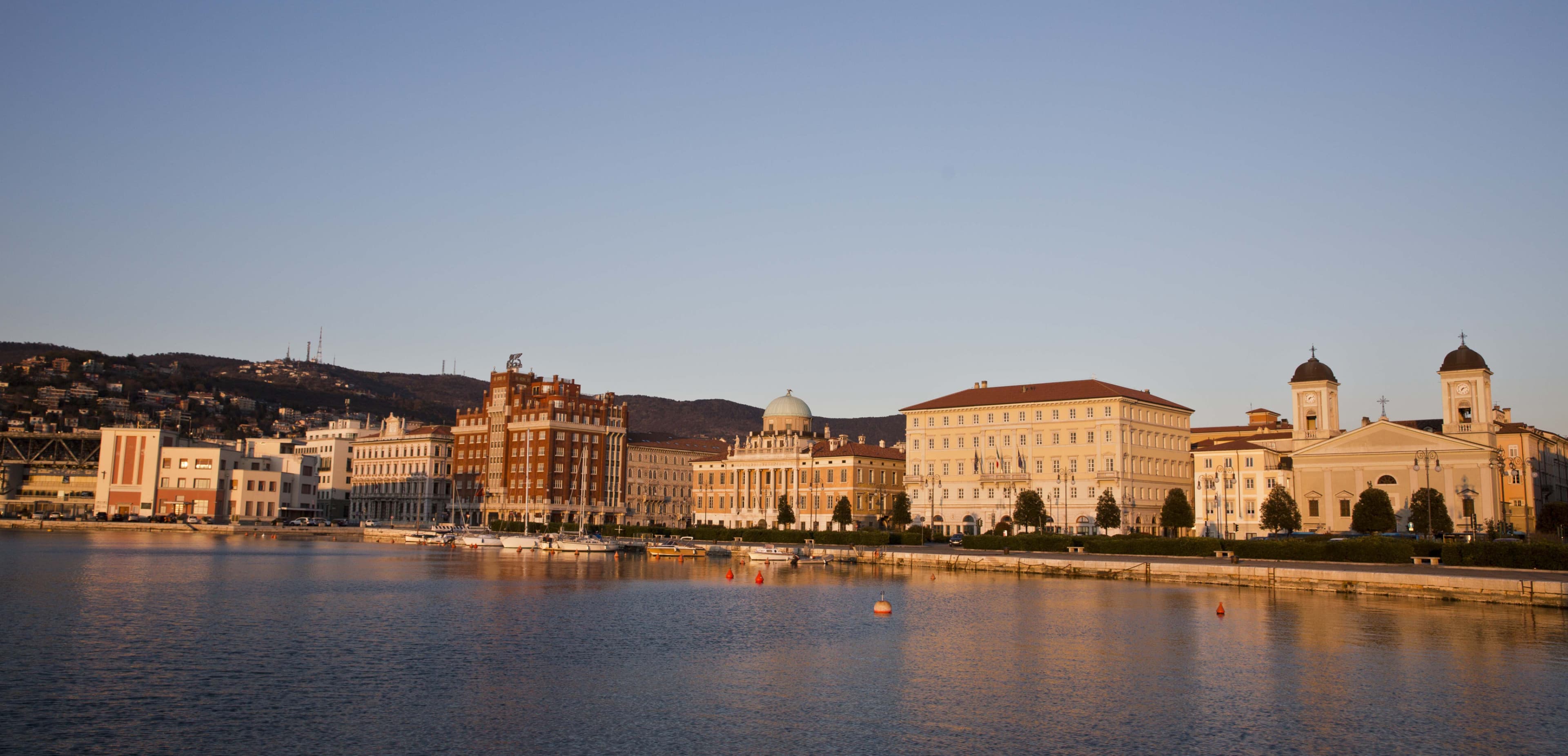 View of the harbour in sunset lighting, showing the beauty of Trieste