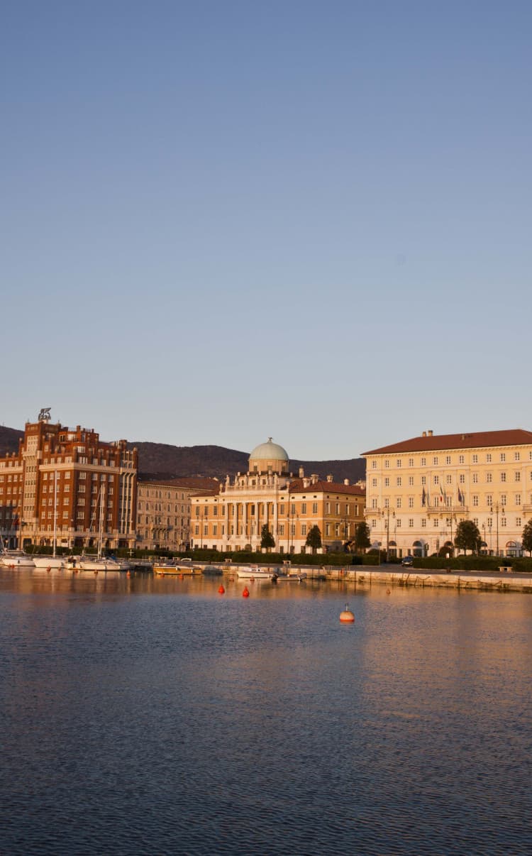 View of the harbour in sunset lighting, showing the beauty of Trieste