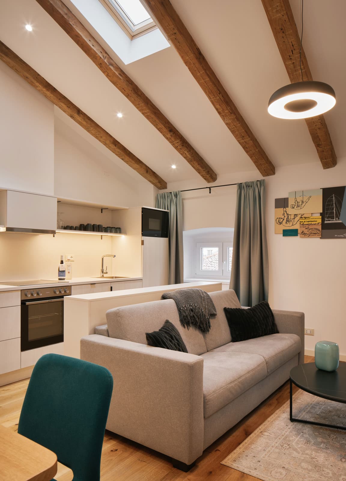 Gezeigt wird das Wohnzimmer eines gemütlichen Studios mit einer Couch, die sich in ein Bett umwandeln lässt.