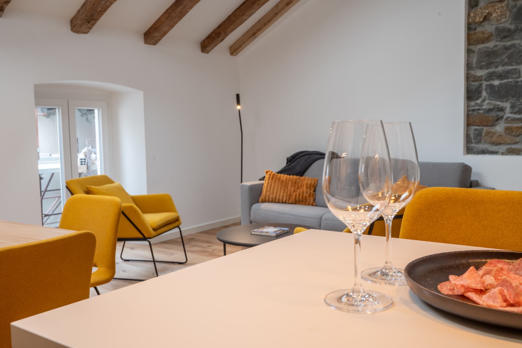 The cozy living room features an open floor plan, that opens up the view onto the wodden roof beams.