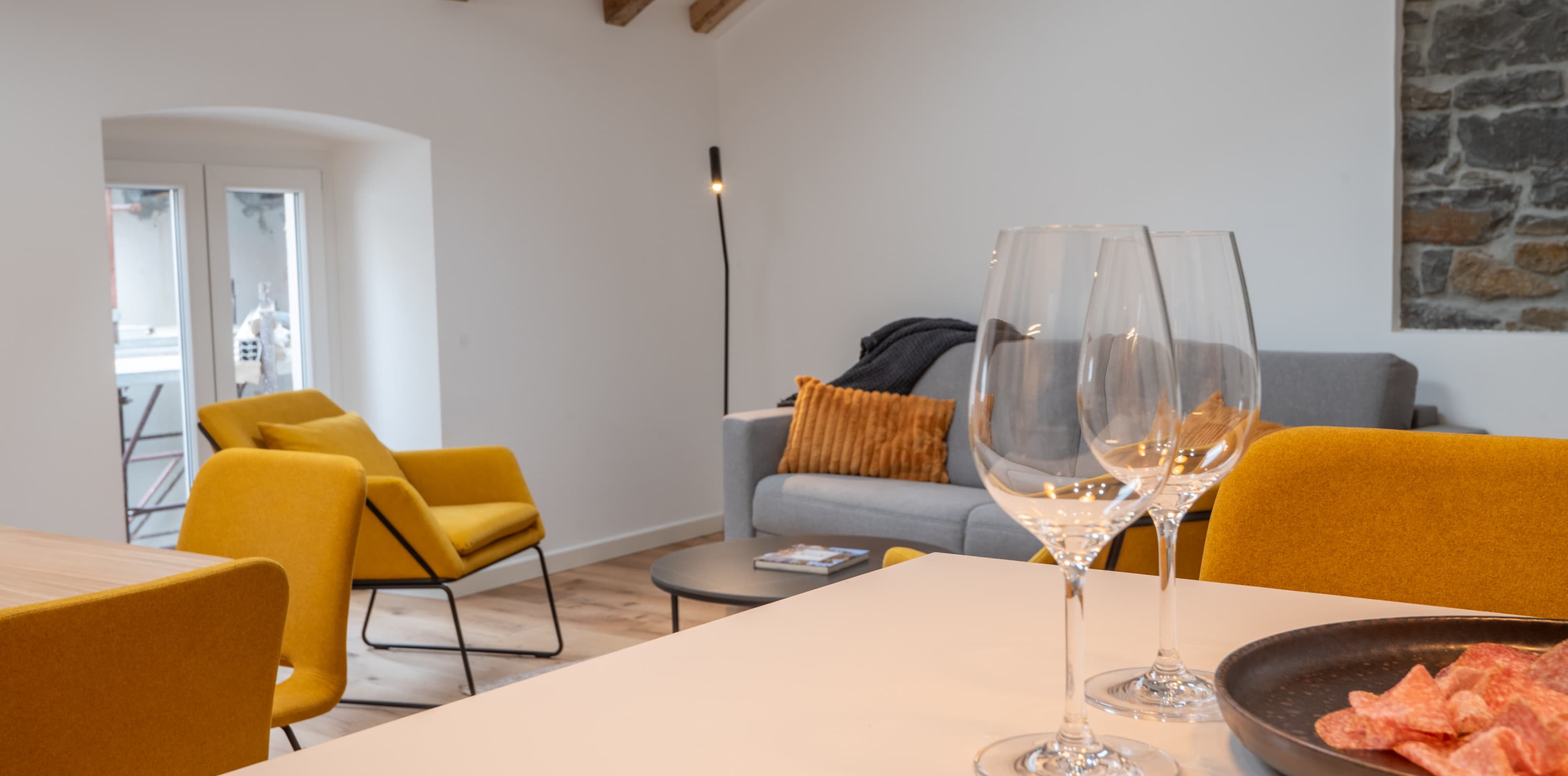 Das gemütliche Wohnzimmer hat einen offenen Grundriss, der den Blick auf die Holzbalken im Dach freigibt.