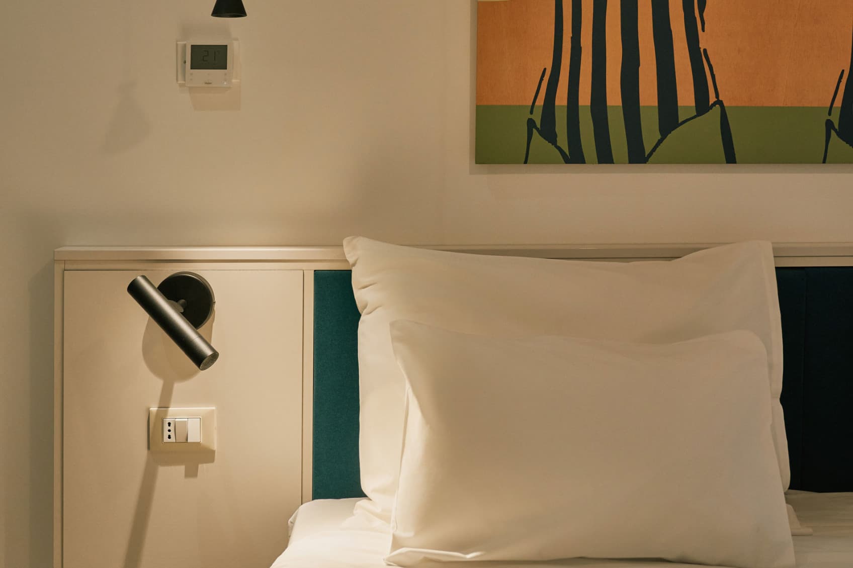 Sen è un primo piano della camera da letto del Comfy Studio, che mostra l'opera d'arte sullo sfondo e parte del letto matrimoniale.