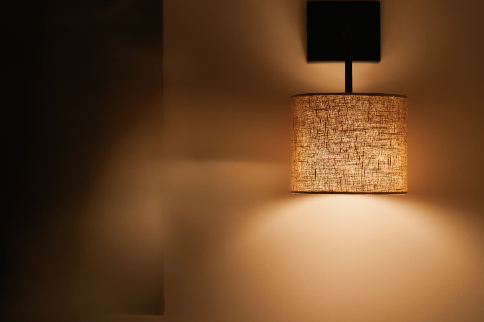 L'immagine mostra un primo piano di una lampada che illumina con una luce soffusa. Mostra l'eleganza e l'atmosfera urban chic dello studio Comfy.