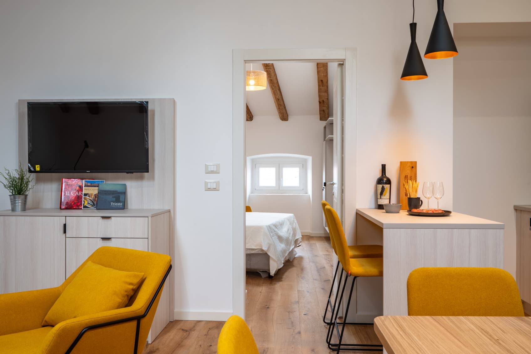 View towards the seperated bedroom, while the colour of a warm yellow sets diffferent accents in the whole apartment.