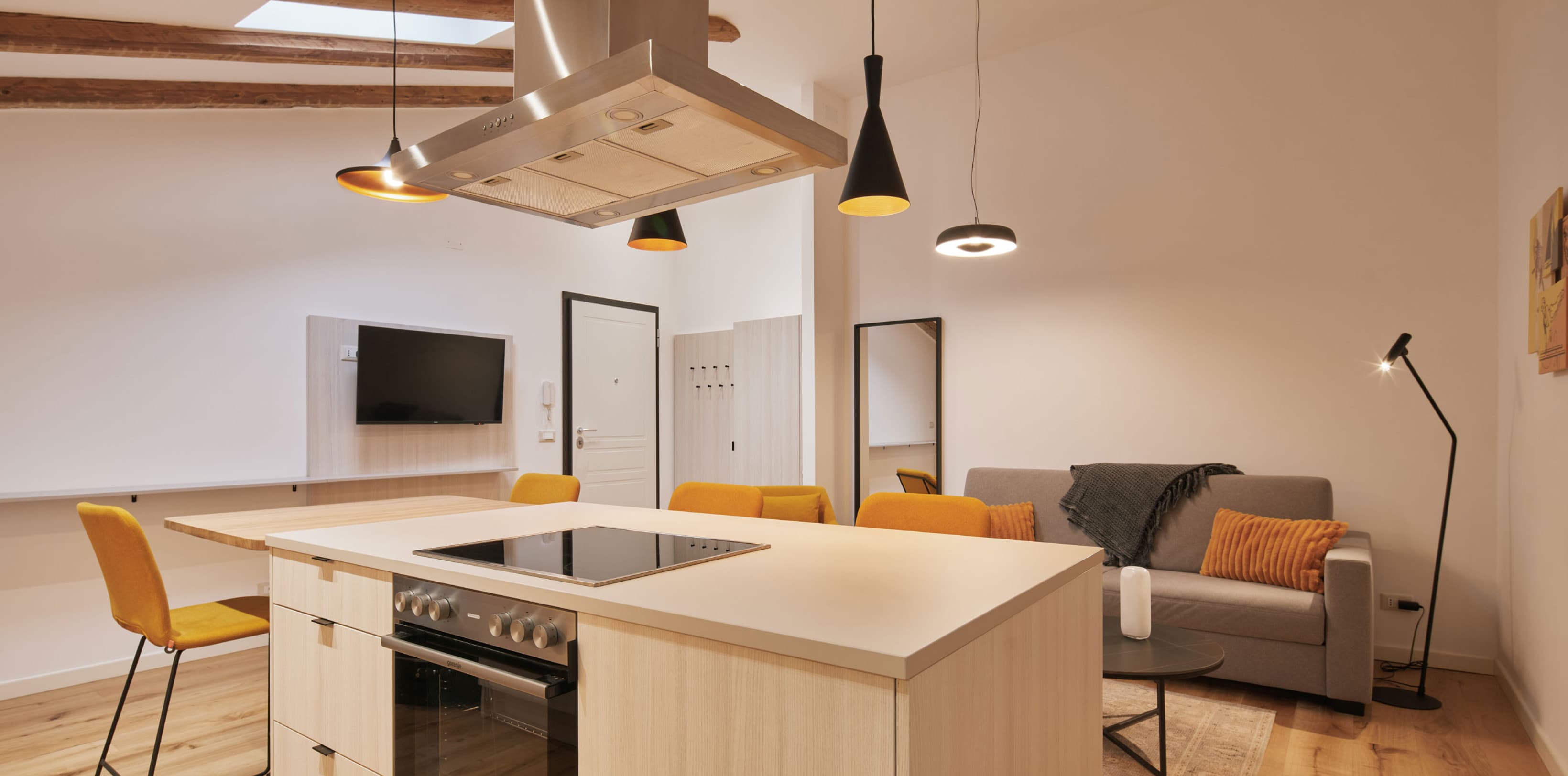 Pictured is the kitchen of the Spacy studio, with a cooking island in the front and middle of the room. In the back you can see the couch, which can be converted into a bed as well.