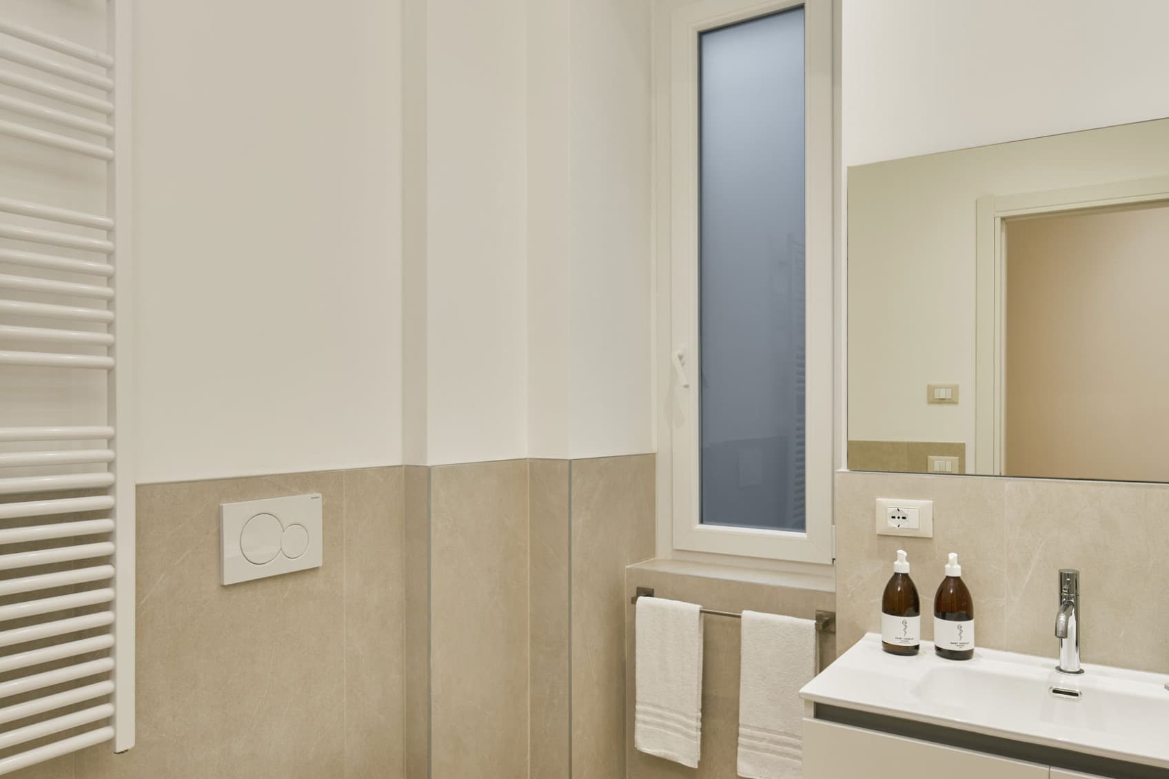 È raffigurato il bagno di un ampio monolocale con WC a sinistra e lavandino a destra.