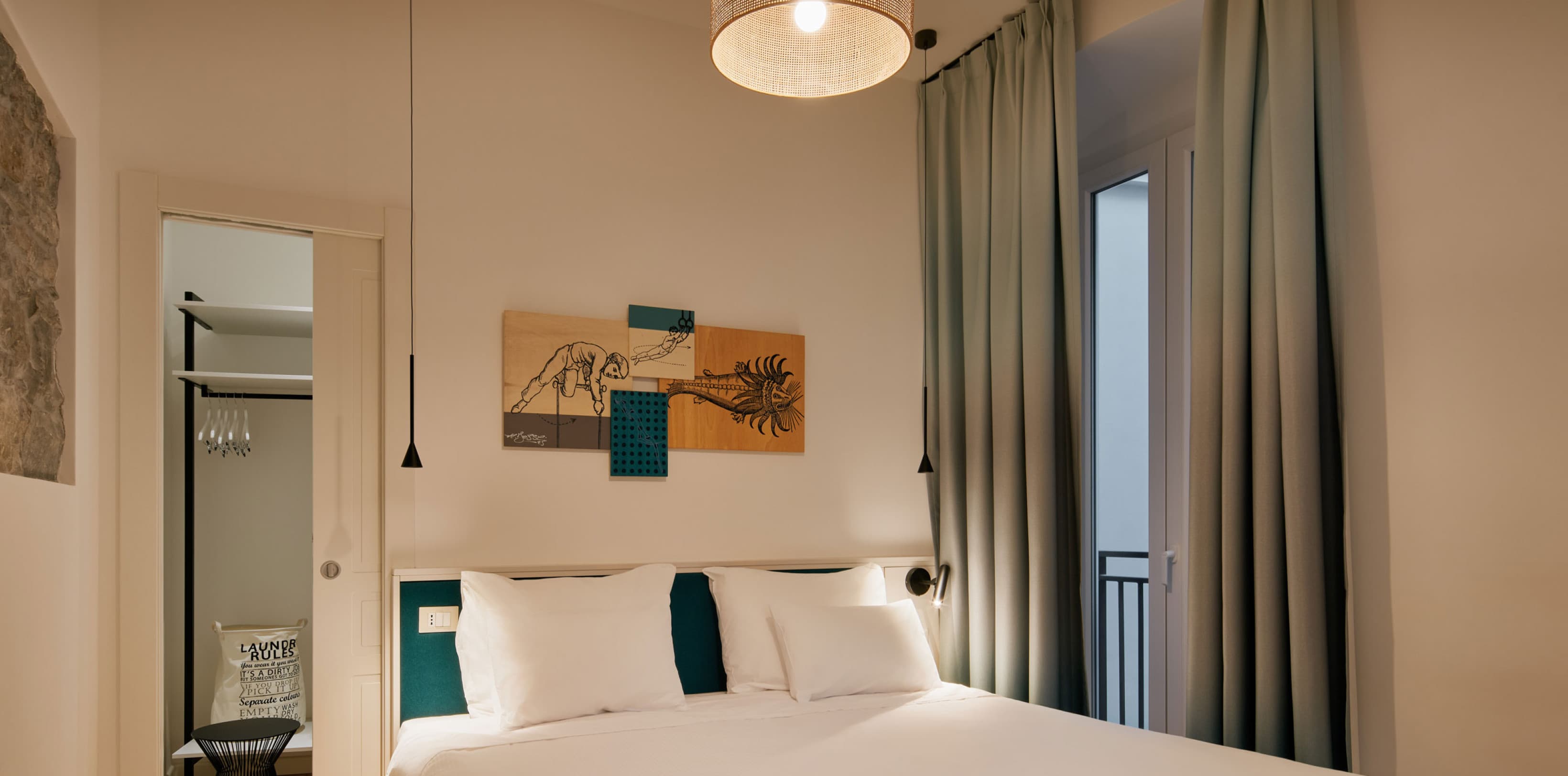 Pictured is the bedroom of the Spacy studio. In the back is an entrance to an open closet and to the right side is a french balcony, opening up to the inner courtyard.