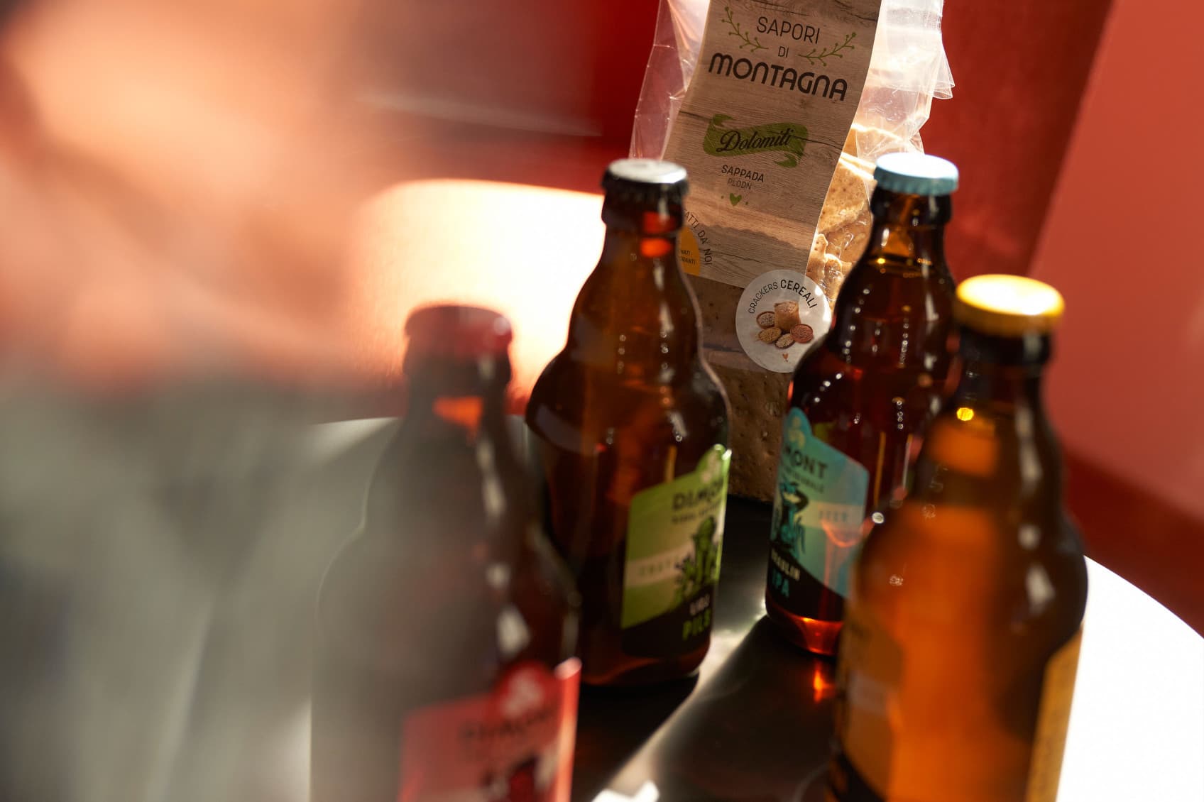 Pictured are several beer bottels on a table at URBANAUTS. Add your after work drink for your future stay.