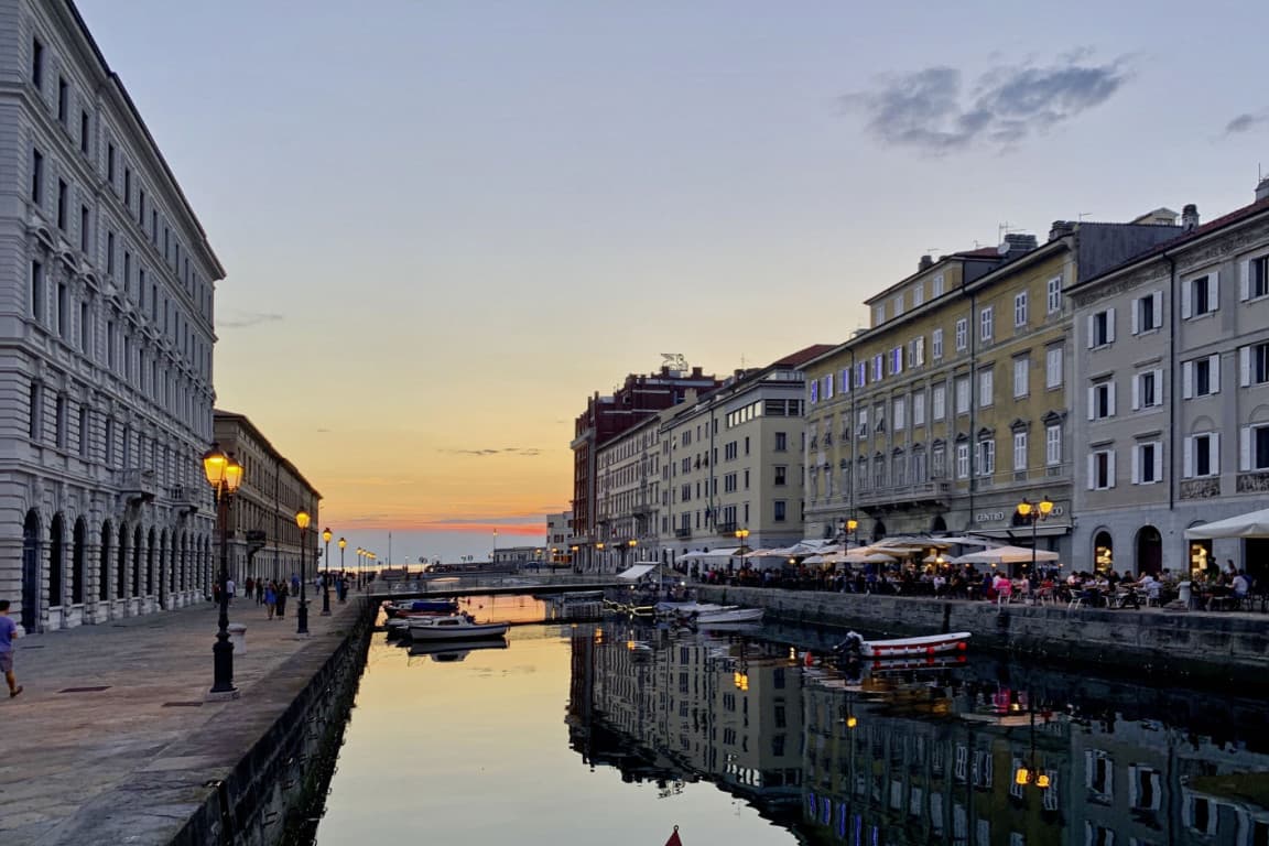 View towards the harbour of Trieste during sunset, with many restaurants on the right side.