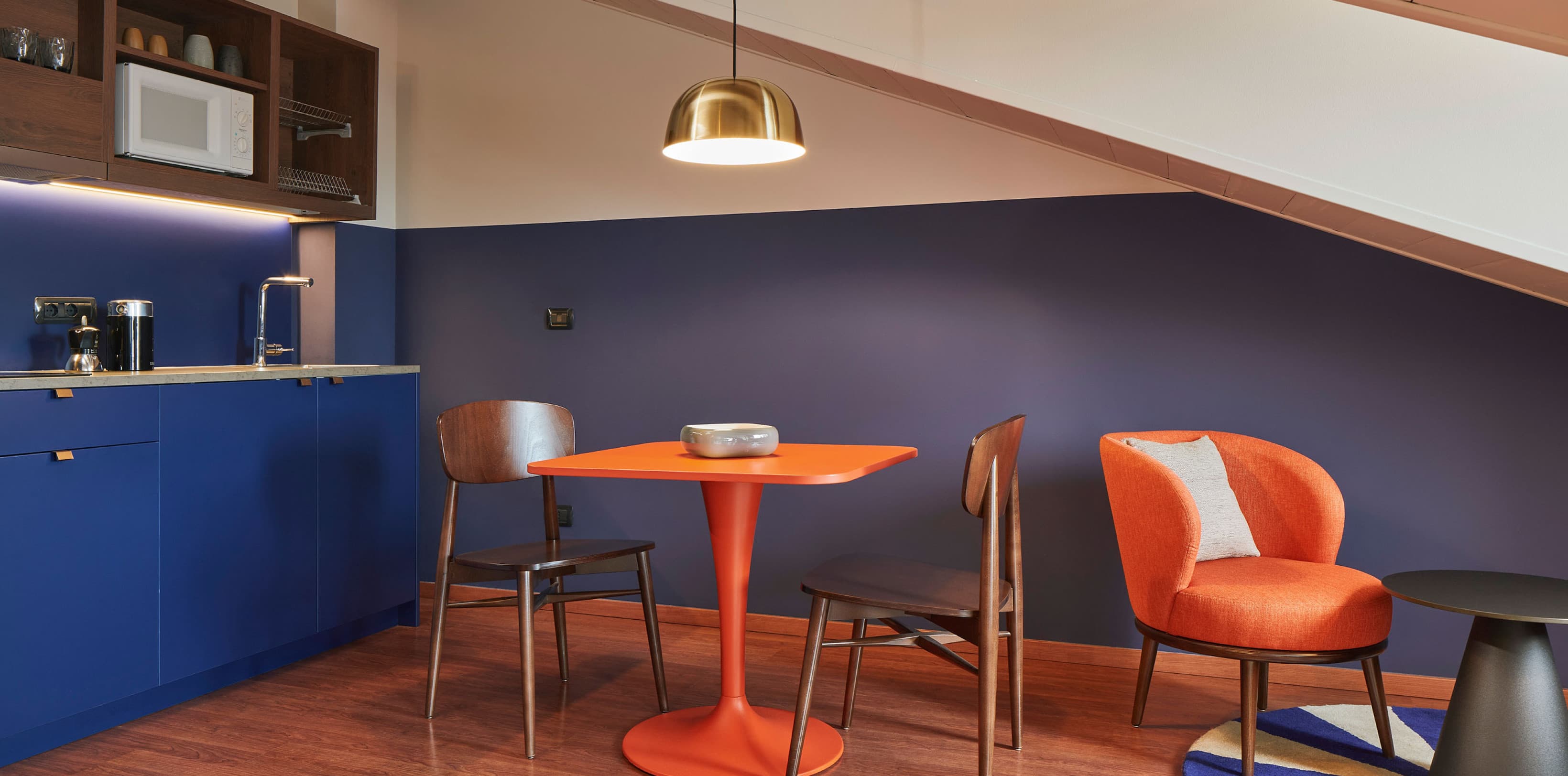 Cozy Studios room 605, view of the living area with kitchen and dining table directly under the roof