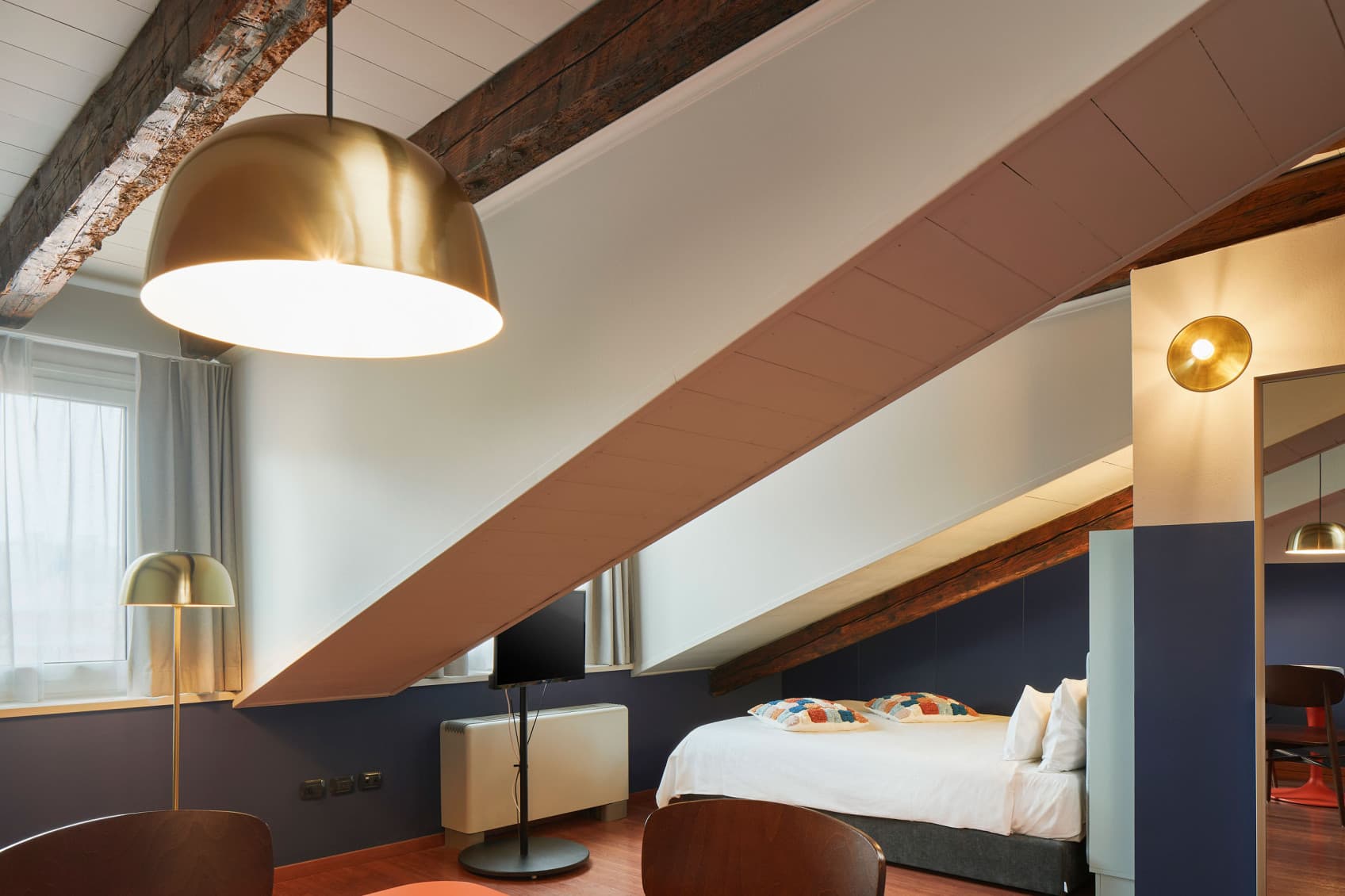 Cozy Studio 605, view of the bed under the roof and the rest of the room.