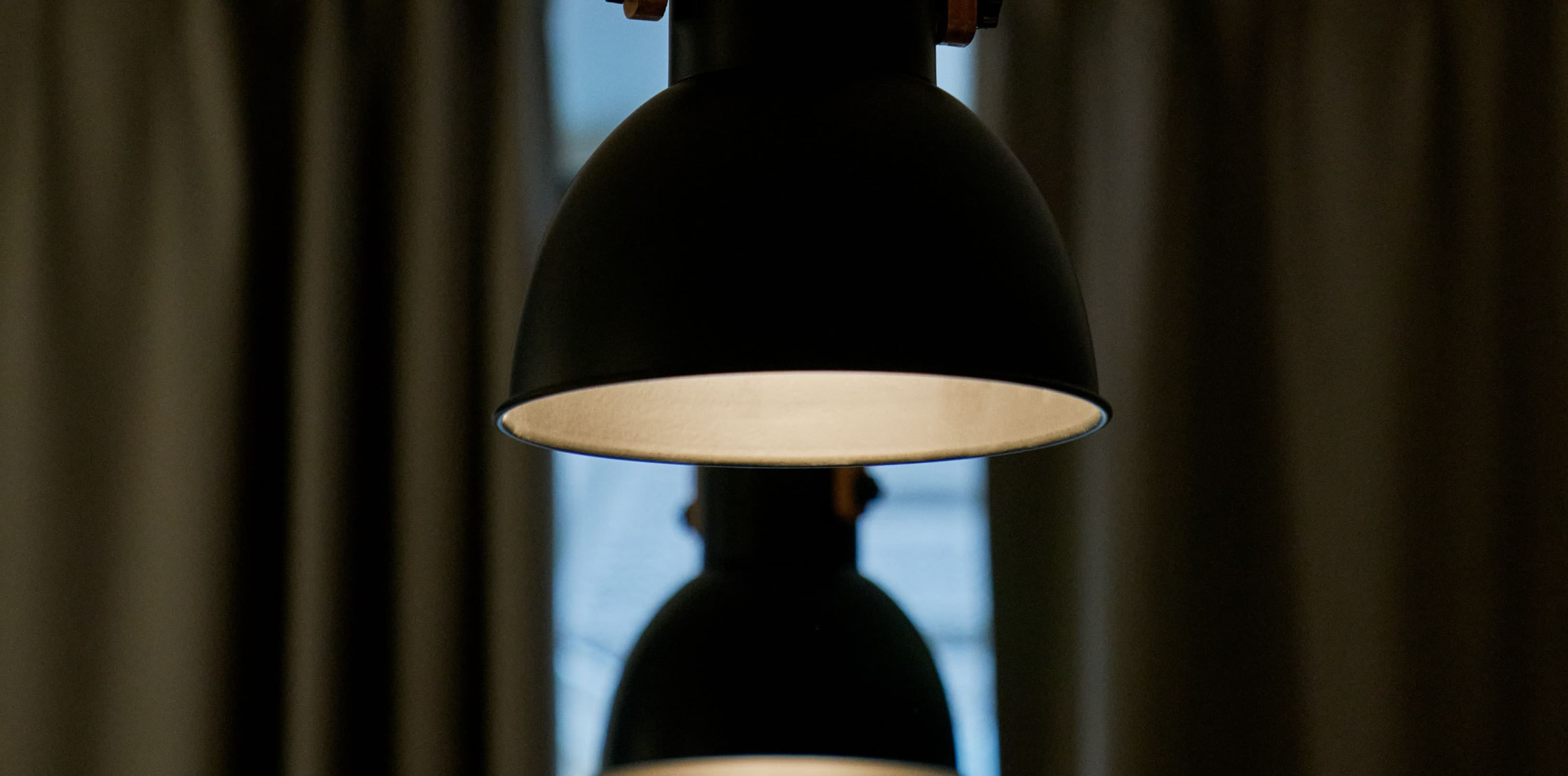 Si vedono tre lampade industriali appese in fila nei loft della strada. Fanno parte dell'aspetto progettuale che mette in risalto l'individualità degli spazi.