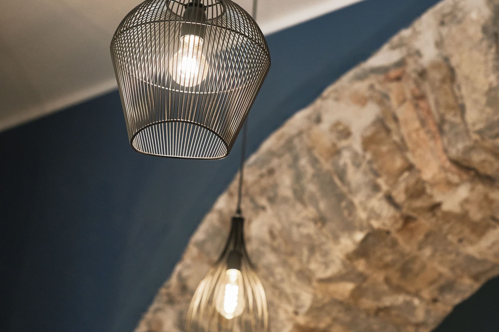 Zu sehen ist ein Detailbild der wunderschön renovierten Geschäfte. Der Steinbogen wird durch eine moderne, urbane Lampe ergänzt, die das Konzept von URBANAUTS unterstreicht, Neues mit Altem zu verbinden.